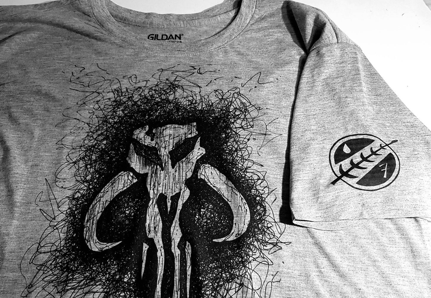 Star Wars t-shirt featuring the Mandalorian bantha skull logo as worn by Boba Fett. Hand drawn Bounty Hunter logo