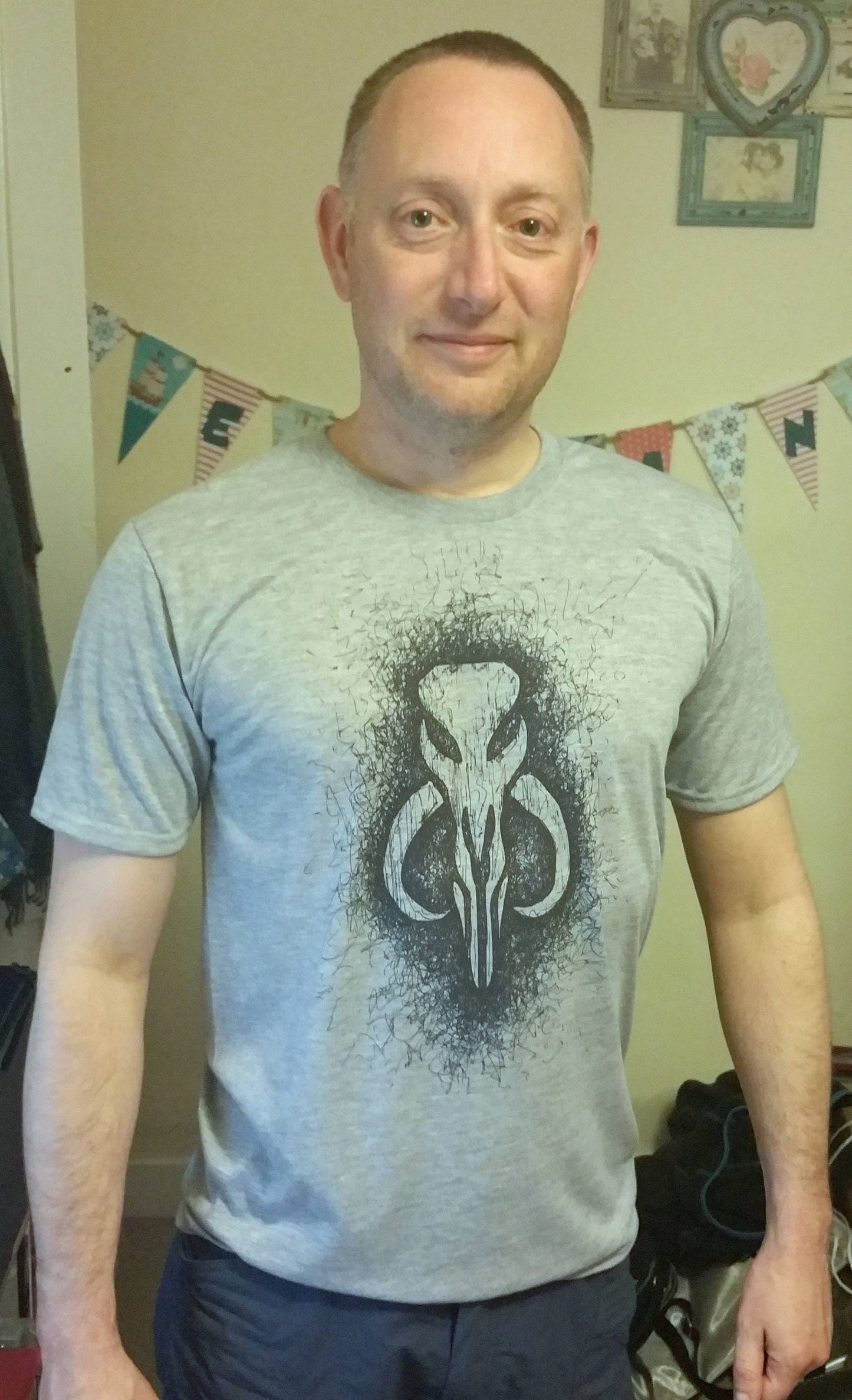 Star Wars t-shirt featuring the Mandalorian bantha skull logo as worn by Boba Fett. Hand drawn Bounty Hunter logo