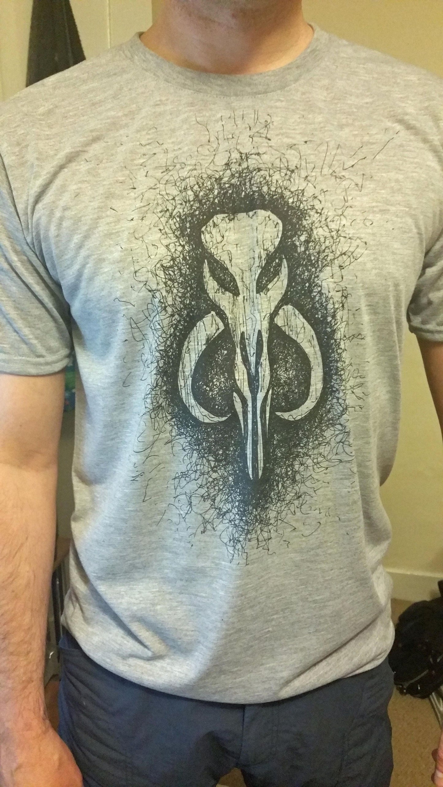 Star Wars t-shirt featuring the Mandalorian bantha skull logo as worn by Boba Fett. Hand drawn Bounty Hunter logo